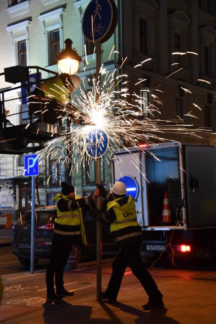 Москва. Сотрудники Центра организации дорожного движения (ЦОДД) во время замены дорожных знаков на знаки уменьшенного размера на улице Большая Никитская.