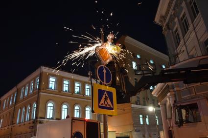 Москва. Сотрудники Центра организации дорожного движения (ЦОДД) во время замены дорожных знаков на знаки уменьшенного размера на улице Большая Никитская.