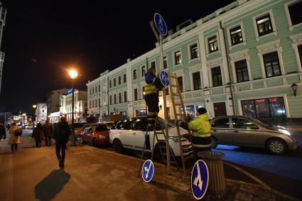 Москва. Сотрудники Центра организации дорожного движения (ЦОДД) во время замены дорожных знаков на знаки уменьшенного размера на улице Большая Никитская.