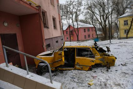 Украина, Донецк. Автомобиль во дворе жилого дома, поврежденный в результате артиллерийского обстрела украинскими силовиками.