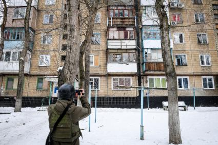 Украина, Донецк. Корреспондент `Комсомольской правды` Александр Коц возле жилого дома на улице Чапаева в Киевском районе, пострадавшем в результате артиллерийского обстрела украинскими силовиками.