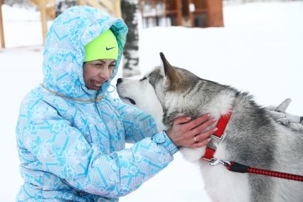 Нижний Новгород. Девушка во время общения с собакой породы хаски на горнолыжной базе `Терраски-Парк`.