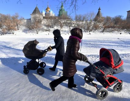 Москва. Женщины с колясками  гуляют  у стен Новоспасского монастыря.