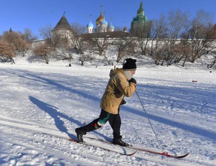 Москва. Пожилой мужчина катается на лыжах у стен Новоспасского монастыря.