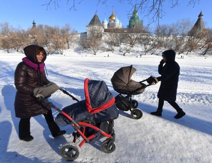 Москва. Женщины с колясками  гуляют  у стен Новоспасского монастыря.