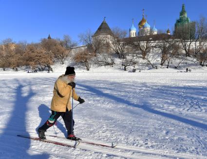 Москва. Пожилой мужчина катается на лыжах у стен Новоспасского монастыря.