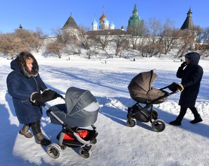 Москва. Женщины с колясками  гуляют  у стен Новоспасского монастыря.