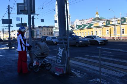 Москва.  Женщина с коляской у пешеходного перехода.