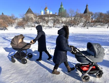 Москва. Женщины с колясками  гуляют  у стен Новоспасского монастыря.