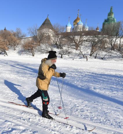 Москва. Пожилой мужчина катается на лыжах у стен Новоспасского монастыря.