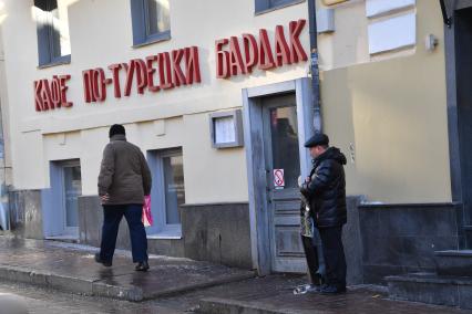 Москва.  Мужчина с сигаретой на одной из улиц города.