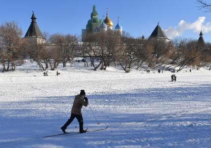 Москва. Пожилой мужчина катается на лыжах у стен Новоспасского монастыря.