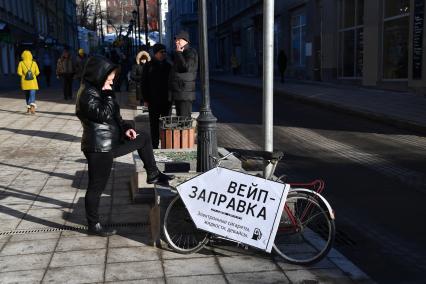 Москва.  Люди курят на улице .