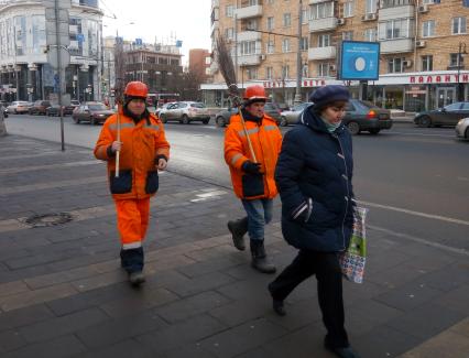 Москва. Дворники с метлами на улице города.