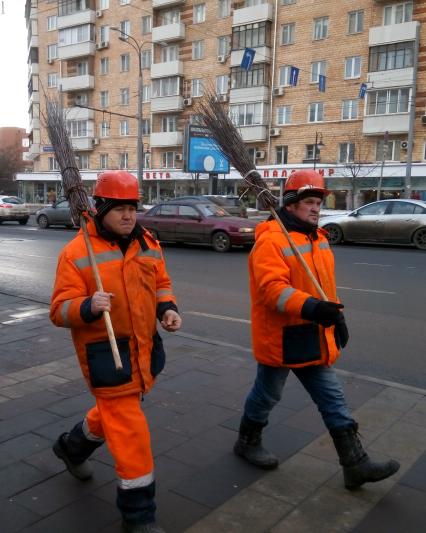 Москва. Дворники с метлами на улице города.