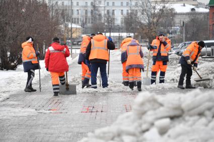 Москва. Сотрудники коммунальных служб очищают тротуар от снега.