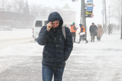 Нижний Новгород. Люди идут по  улице во время метели.