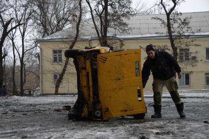 Украина, Донецк. Житель Киевского района возле автомобиля,  пострадавшего в результате артиллерийского обстрела украинскими силовиками.