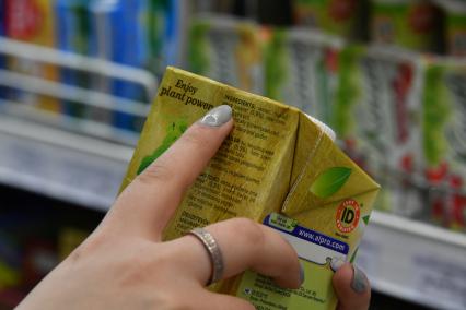 Москва. Покупательница изучает состав продуктов питания.