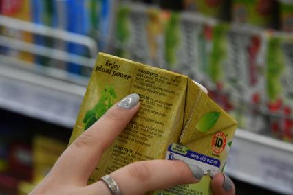 Москва. Покупательница изучает состав продуктов питания.