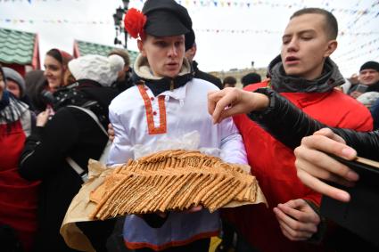 Москва.  Раздача блинов на фестивале `Московская Масленица` на Манежной площади.