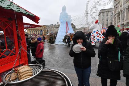 Москва. Участники фестиваля `Московская Масленица`  едят блины на Манежной площади.