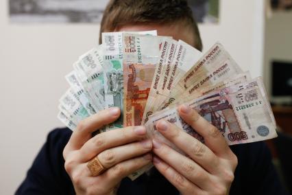Ставрополь. Мужчина держит в руках денежные купюры.