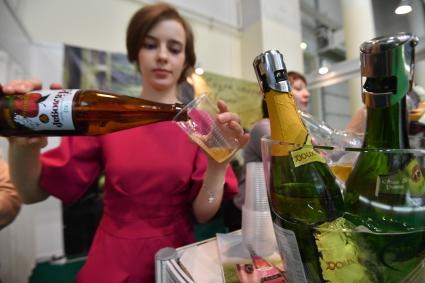 Москва. Женщина разливает сидр на международной выставке продуктов питания , напитков и сырья `Продэкспо-2017` .