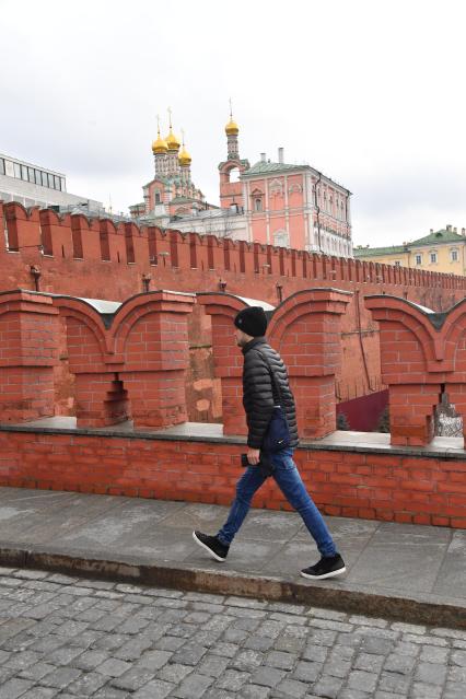 Москва. Молодой человек идет по Троицкому мосту Кремля.