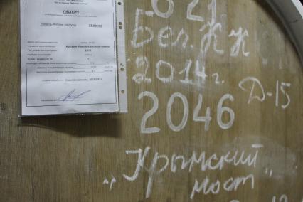 Крым, Масандра.  Винные бочки в подвале  винодельческого комплекса  `Массандра` с вином  2014 года `Крымский мост.