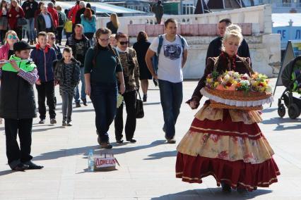 Крым,  Севастополь. Женщина продает цветы  на  набережной.
