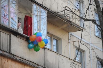 Москва.  Женщина на балконе пятиэтажного жилого дома в районе Матвеевское.