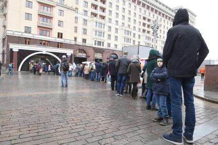 Москва.  Посетители стоят в очереди в музей археологии Москвы на Манежной площади.