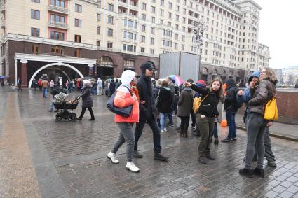 Москва.  Посетители стоят в очереди в музей археологии Москвы на Манежной площади.