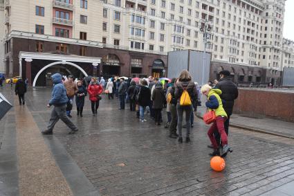 Москва.  Посетители стоят в очереди в музей археологии Москвы на Манежной площади.