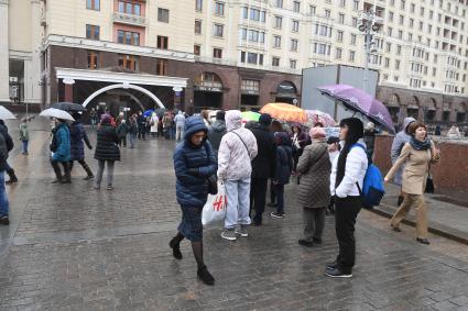 Москва.  Посетители стоят в очереди в музей археологии Москвы на Манежной площади.