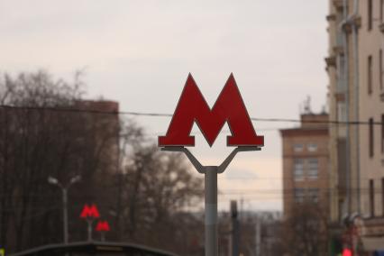 Москва.   Эмблема метрополитена `М` у входа в метро.