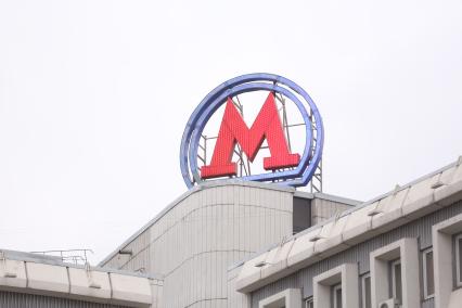 Москва.   Эмблема метрополитена `М` у входа в метро.