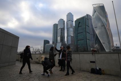 Москва.  Туристы фотографируют  и делают селфи  на фоне Делового центра  Москва-Сити  на набережной Тараса Шевченко.