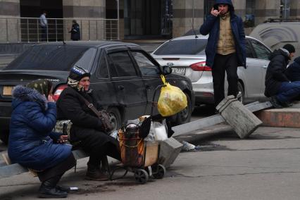 Москва.   Женщины сидят у Киевского вокзала.