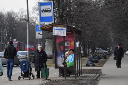 Москва.  Люди на остановке общественного транспорта.