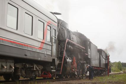 Карелия , Сортавала . Машинист проверяет ретро-паровоз в горном парке `Рускеала`.