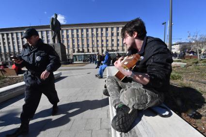 Москва.  Молодой человек играет на гитаре  на Триумфальной площади.