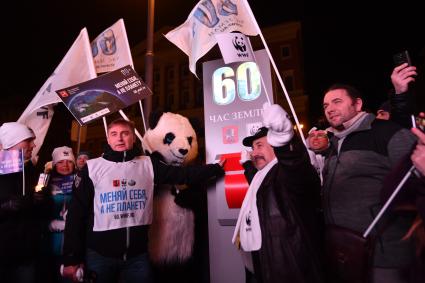 Москва .  Руководитель Департамента природопользования и охраны окружающей среды города Антон Кульбачевский  (слева) у символического рубильника  на Тверской улице  во время экологической акции `Час земли`.