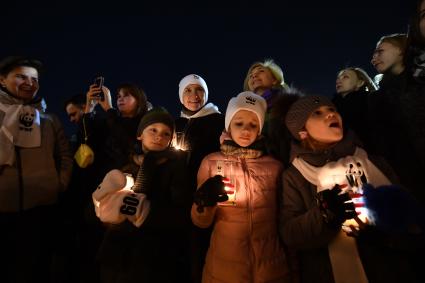 Москва . Певица Диана Арбенина  ( в белой шапочке)  со своими  детьми во время  экологической акции `Час земли` на Красной площади.