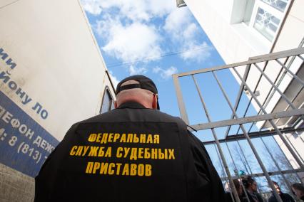 Ленинградская область, Приозерск. Судебный пристав у городского суда, куда был доставлен предприниматель Владимир Бельский, подозреваемый в умышленном наезде на ребенка. Суд арестовал его на два месяца.