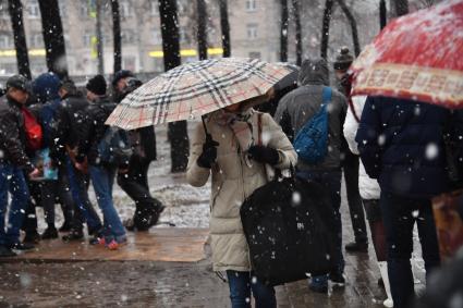 Москва. Люди идут по парку в снегопад.