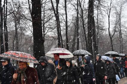 Москва. Люди идут по парку в снегопад.