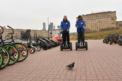 Москва. Сотрудники проката едут на сигвеях в парке Победы.