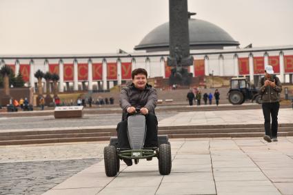 Москва. Корреспондент `Комсомольской правды ` Павел Клоков тестирует веломобиль на дорожках парка  Победы.